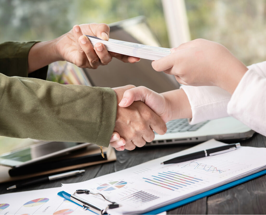 People shaking hands after signing a contract