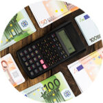 A calculator surrounded by Euro notes.